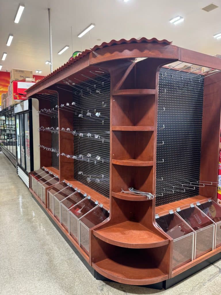 Stained pegboard display island with corner shelves and acrylic bins